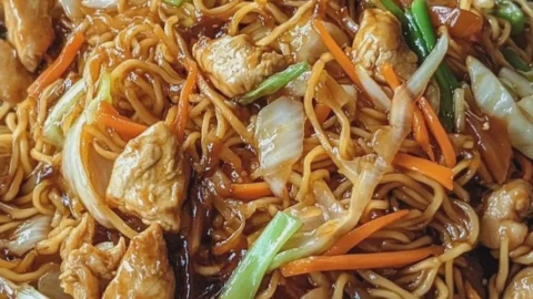 Hühner-Chow-Mein serviert mit frischem Gemüse und Reis