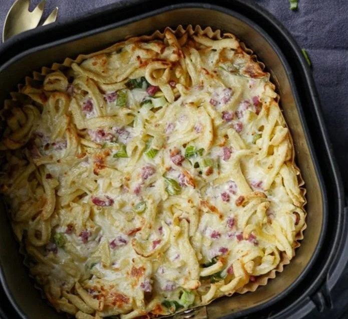Käsespätzle aus dem Airfryer serviert mit Käse und Zwiebeln
