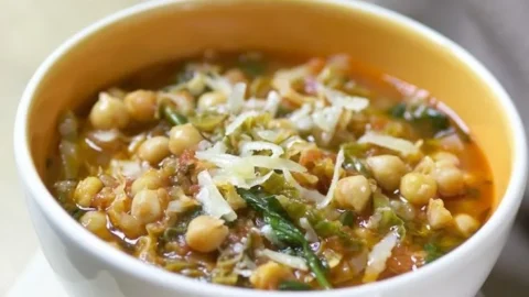 Kichererbsen-Wirsing-Suppe mit Tomaten in einer Schüssel serviert