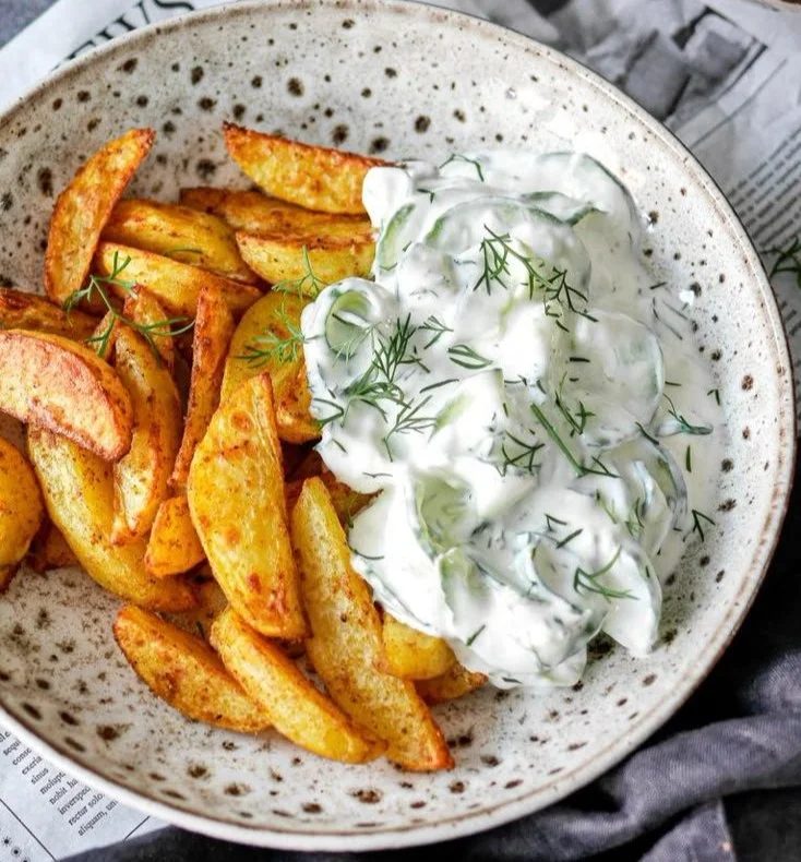 Knusprige Kartoffelspalten serviert mit einem leckeren Gurkendip