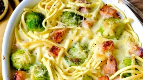 Nudel-Kürbis-Gratin mit Hack und Semmelbrösel-Kruste auf einem Teller serviert.