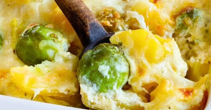 Rosenkohl-Kartoffel-Auflauf mit Käse überbacken, serviert in einer Auflaufform.