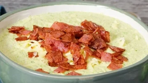 Schüssel mit cremiger Rosenkohlsuppe und geschmolzenem Käse