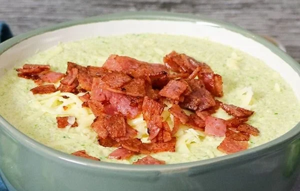 Schüssel mit cremiger Rosenkohlsuppe und geschmolzenem Käse