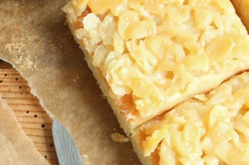 Buttermilchkuchen mit Mandeln auf einem Teller, frisch gebacken