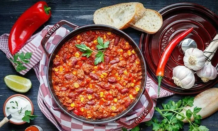 Schale mit leckerem Chili con Carne, serviert mit frischem Brot