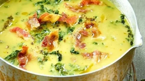 Cremige Wirsingsuppe mit Kartoffeln und Speck in einer Schüssel serviert.
