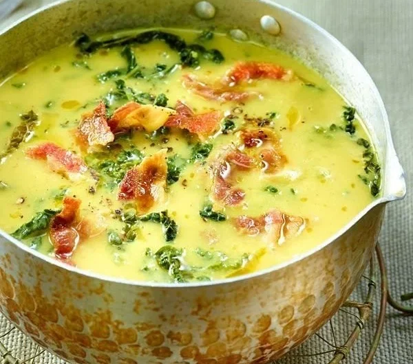 Cremige Wirsingsuppe mit Kartoffeln und Speck in einer Schüssel serviert.