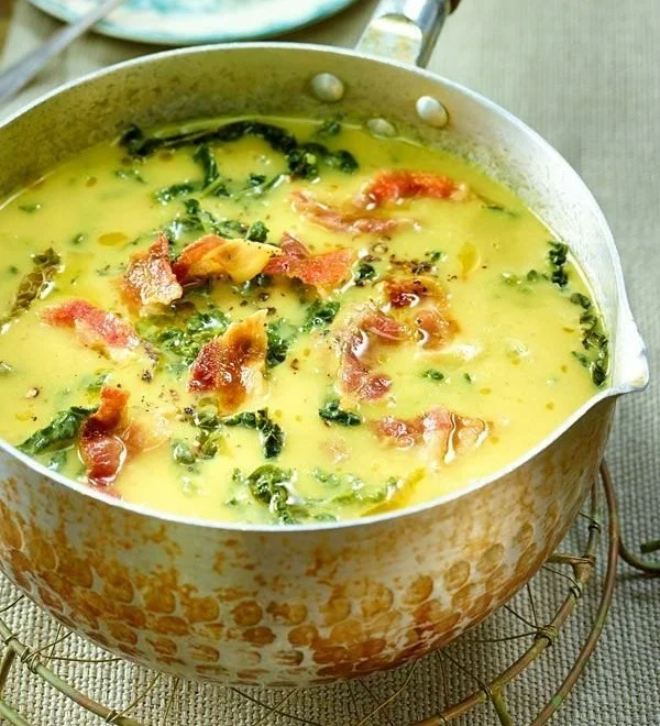 Cremige Wirsingsuppe mit Kartoffeln und Speck in einer Schüssel serviert.