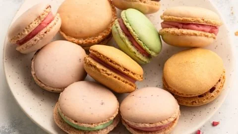 Bunte Macarons auf einem Teller, perfekt nach dem einfachen Grundrezept zubereitet