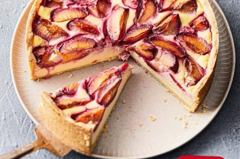 Pflaumenkuchen mit Mürbeteig und Schmand auf einem Teller