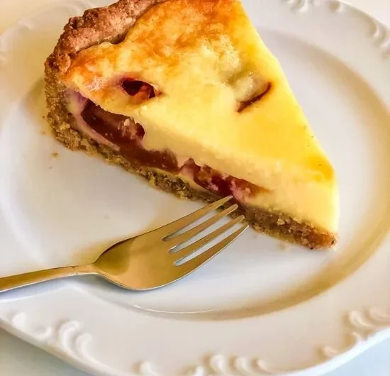 Pflaumenkuchen mit Schmand auf einem Teller, ideal für Dessertideen.