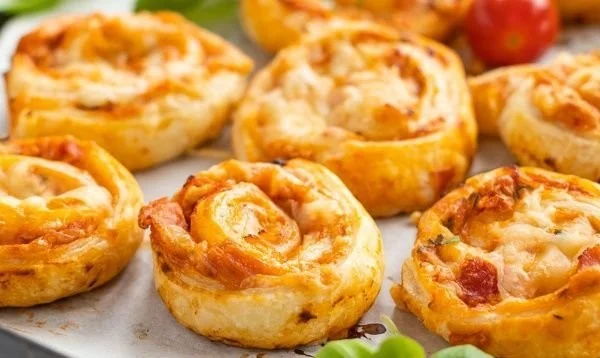 Leckere Pizzaschnecken auf einem Teller serviert, ideal für Snacks oder Partys.
