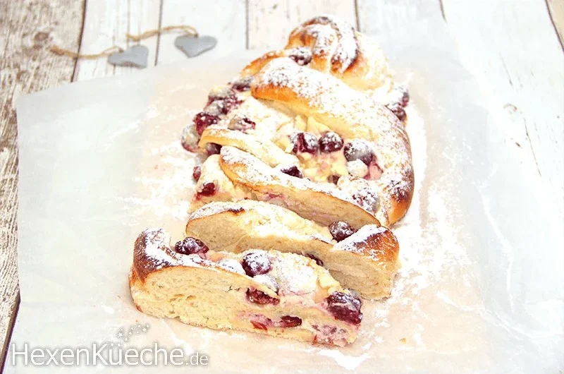 Quarkzopf mit Sauerkirschen auf einem Holzbrett serviert