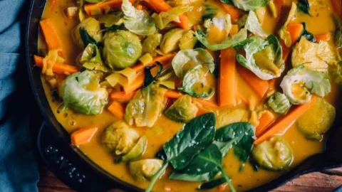 Veganes Rosenkohl-Curry mit Spinat, Karotten und Lauch auf einem Teller