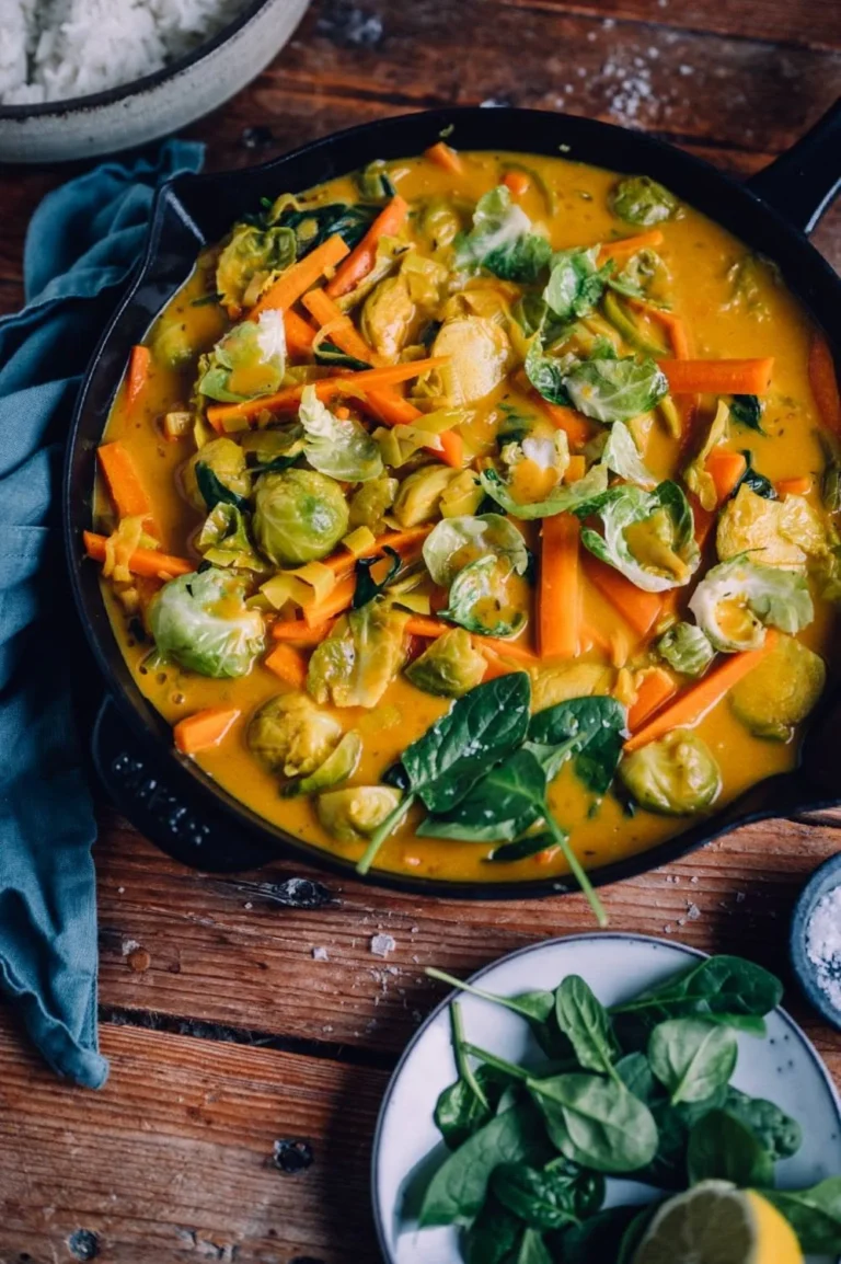 Veganes Rosenkohl-Curry mit Spinat, Karotten und Lauch auf einem Teller