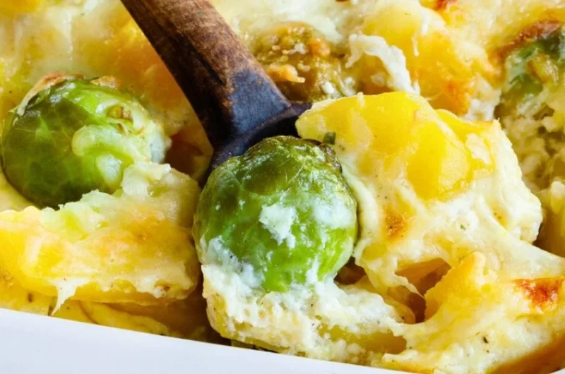 Leckerer vegetarischer Rosenkohl-Kartoffel-Auflauf auf einem Teller serviert