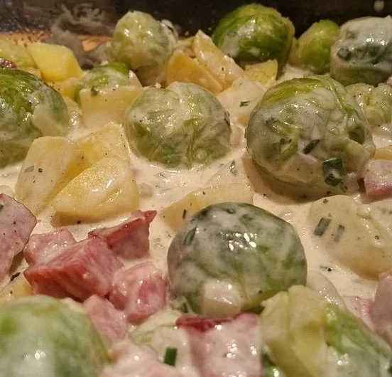 Rosenkohl-Kartoffel-Kasseler-Pfanne serviert in einer Pfanne mit Röstkartoffeln.