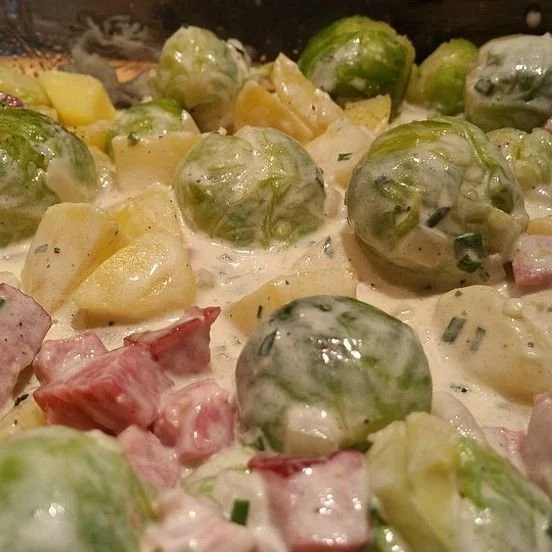 Rosenkohl-Kartoffel-Kasseler-Pfanne serviert in einer Pfanne mit Röstkartoffeln.