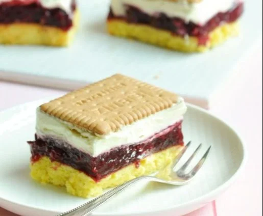 Rote Grütze-Butterkekskuchen mit frischen Früchten auf einem Teller serviert.