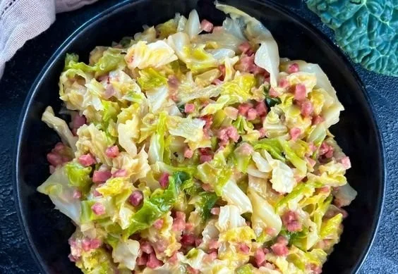 Schnelles Rahmwirsing Rezept mit Speck auf einem Teller serviert.