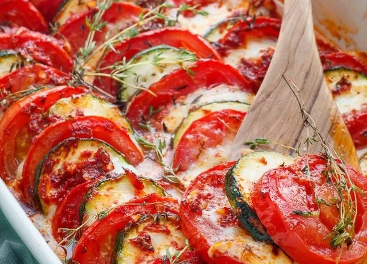 Tomaten Zucchini Auflauf mit Mozzarella auf einem Teller serviert