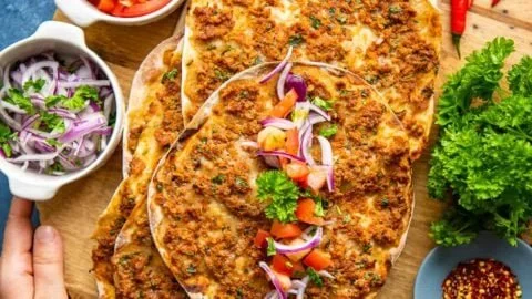 Türkisches Lahmacun mit frischer Füllung auf einem rustikalen Holzbrett