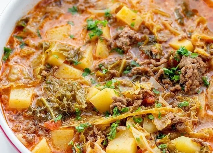 Wirsing Eintopf in einer Schüssel mit frischen Zutaten