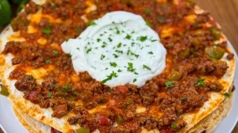 Türkische Lasagne Yaglama mit Knoblauch-Joghurt auf einem Teller serviert.