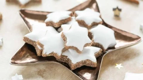 Leckere Zimtsterne Plätzchen auf einem Teller, dekoriert für Weihnachten.