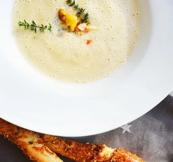 Cremige Maronisüppchen mit Parmesanstangen serviert in einer weißen Schale