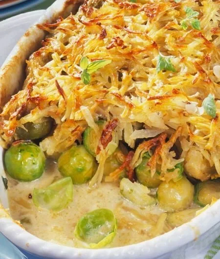Rosenkohl-Auflauf mit Kartoffelkruste auf einem Teller serviert.