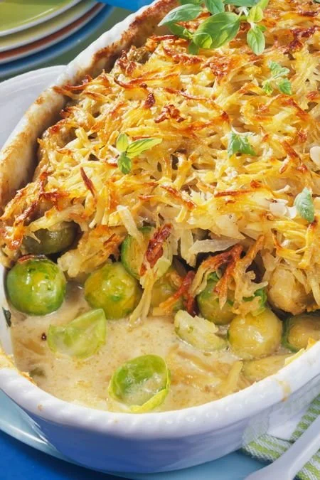 Rosenkohl-Auflauf mit Kartoffelkruste auf einem Teller serviert.