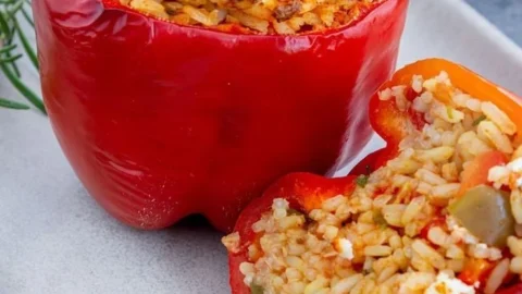 Gefüllte Paprika mit Reis und Feta auf einem Teller angerichtet