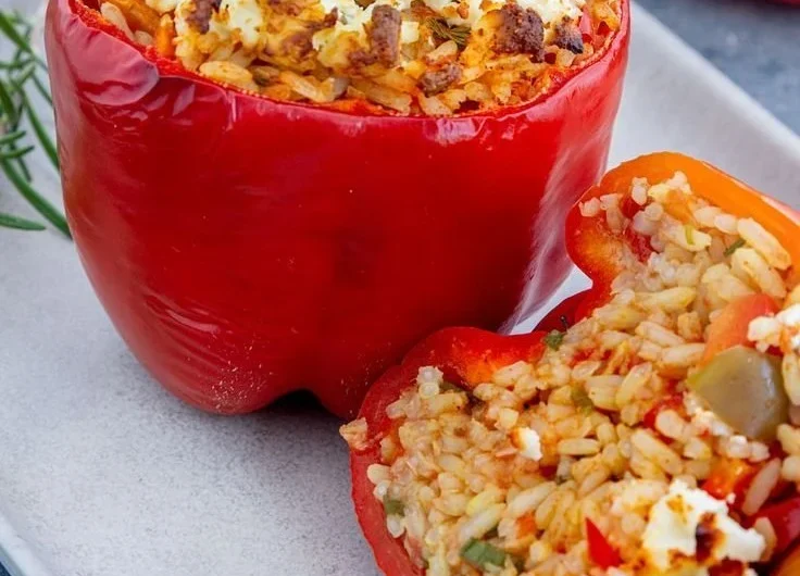 Gefüllte Paprika mit Reis und Feta auf einem Teller angerichtet