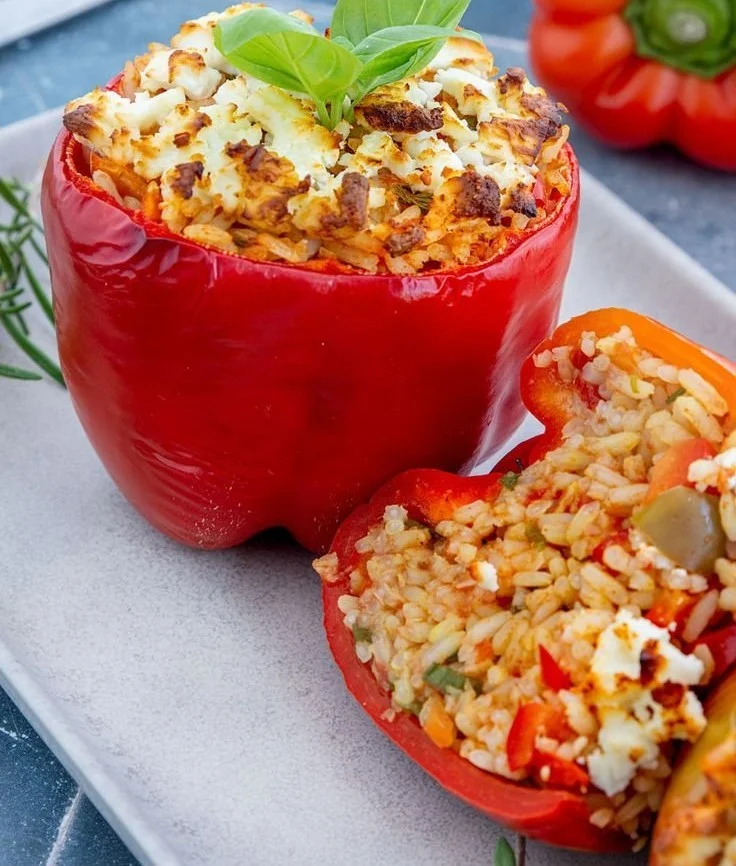 Gefüllte Paprika mit Reis und Feta auf einem Teller angerichtet