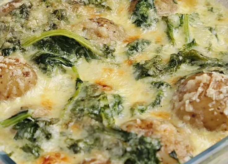 Leckeres Grünkohlauflauf mit Kartoffeln, serviert in einer Auflaufform.