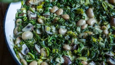 Grünkohlpfanne mit weißen Riesenbohnen serviert in einer Pfanne