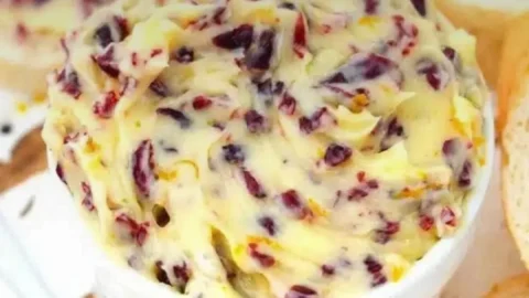 Hausgemachte Honey Cranberry Butter auf einem frischen Brötchen serviert.