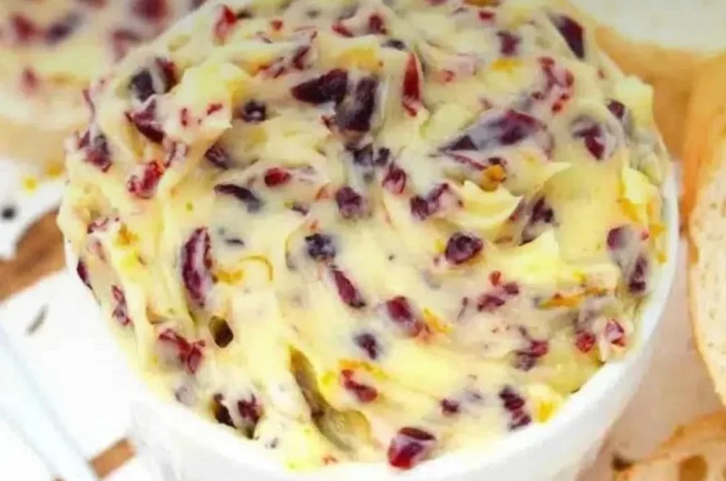 Hausgemachte Honey Cranberry Butter auf einem frischen Brötchen serviert.