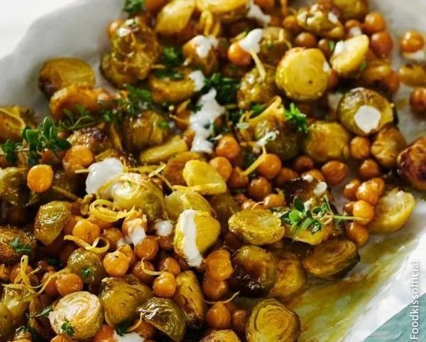 Gerösteter Rosenkohl mit Kichererbsen und Zitronen-Dip auf einem Teller.