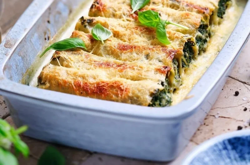 Vegane Grünkohl Cannelloni auf einem Teller serviert mit frischen Zutaten.
